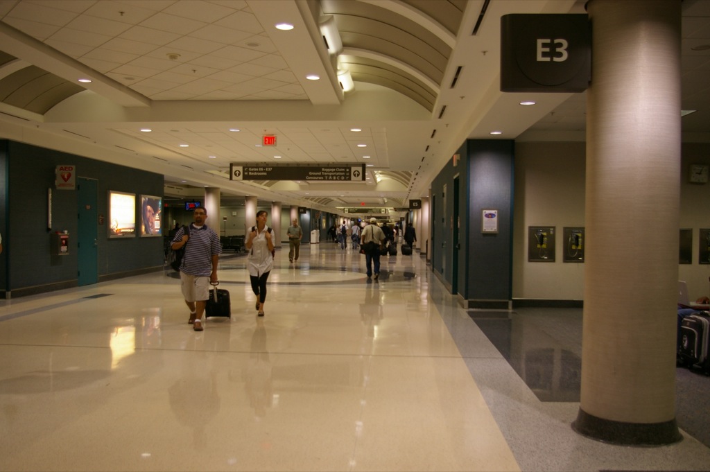 people walking along inside the hallway of a large building