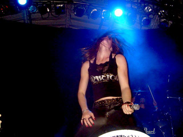 a woman on stage wearing all black in a black outfit