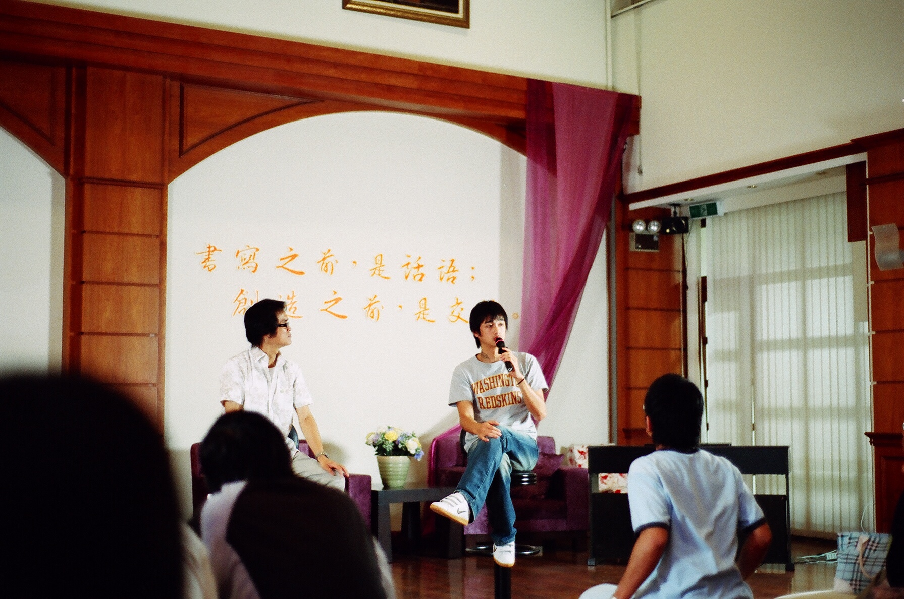 two men are discussing a story at a small meeting