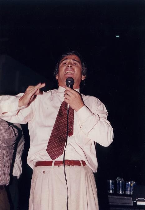 a man holding a microphone, singing and standing