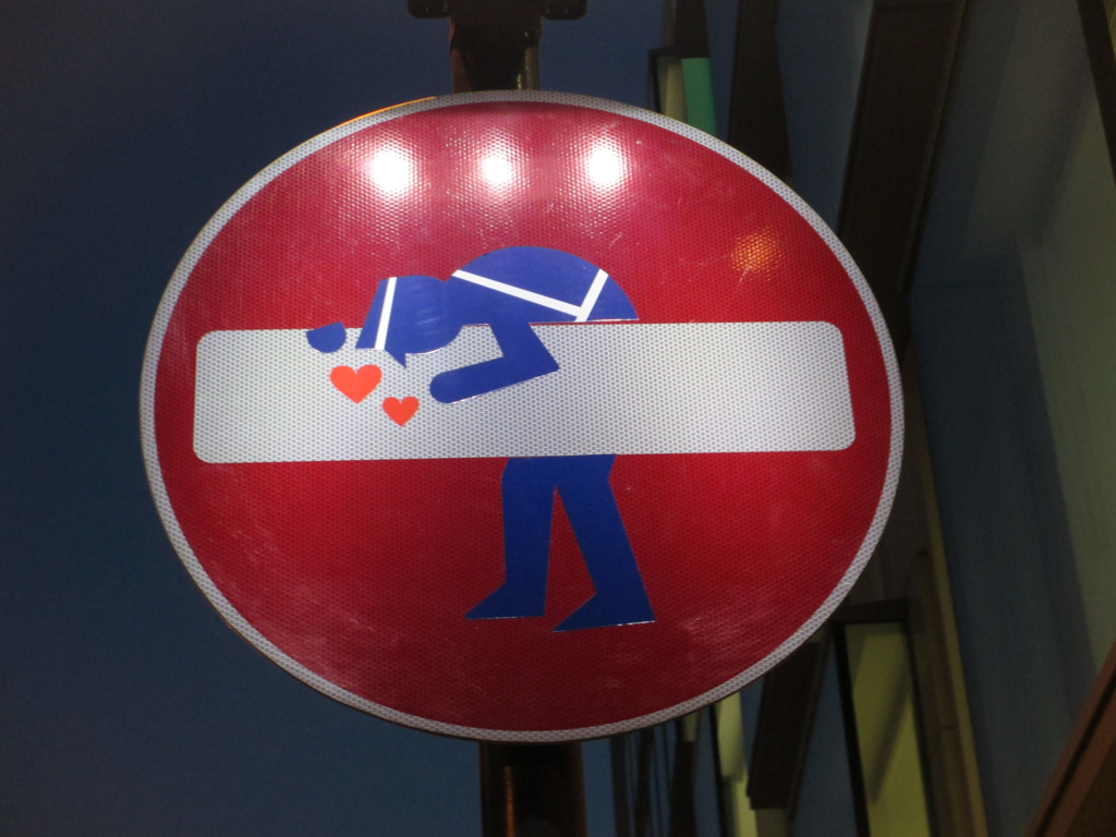 a stop sign with a man hugging a woman