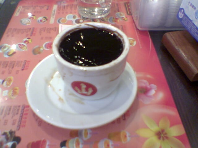 a cup of black liquid sits on the table