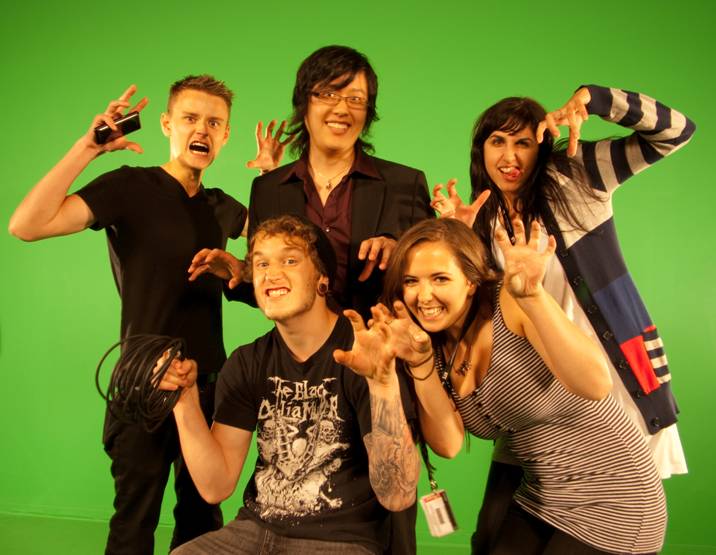 the group of young people are posing together in front of green screen
