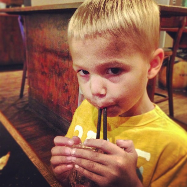 a little boy in a yellow shirt with a banana