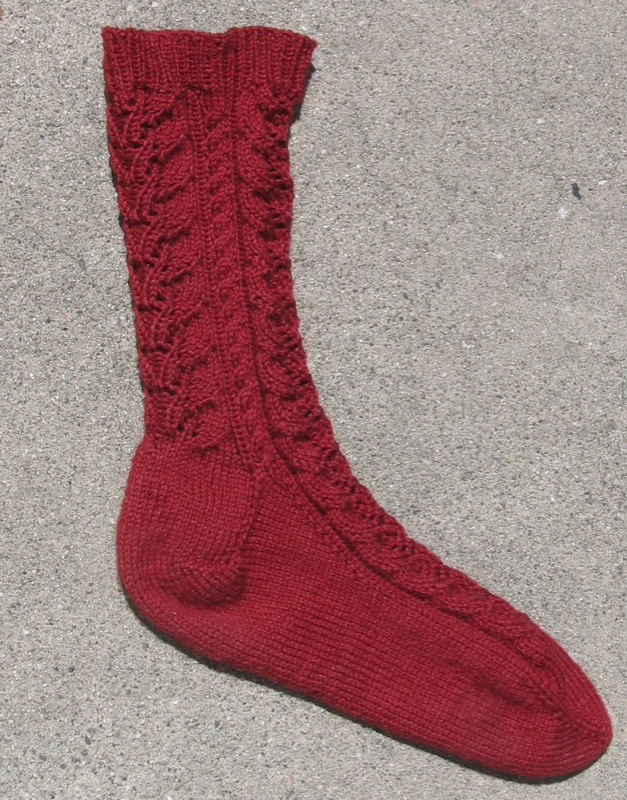 a red knitted pair of socks on the ground