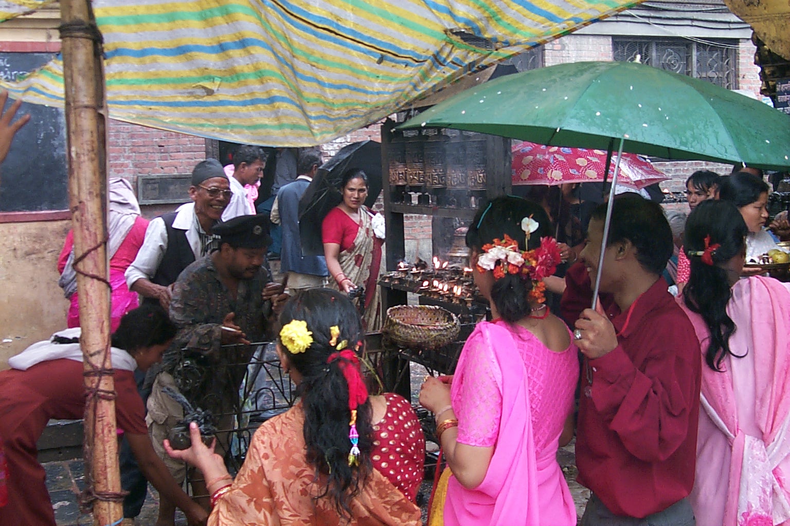 people standing around holding a green umbrella in the rain