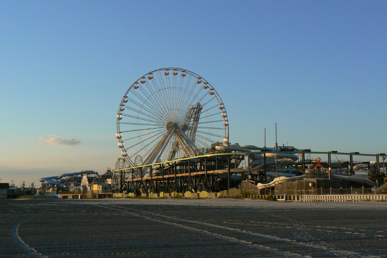 a carnival with a giant wheel in the background