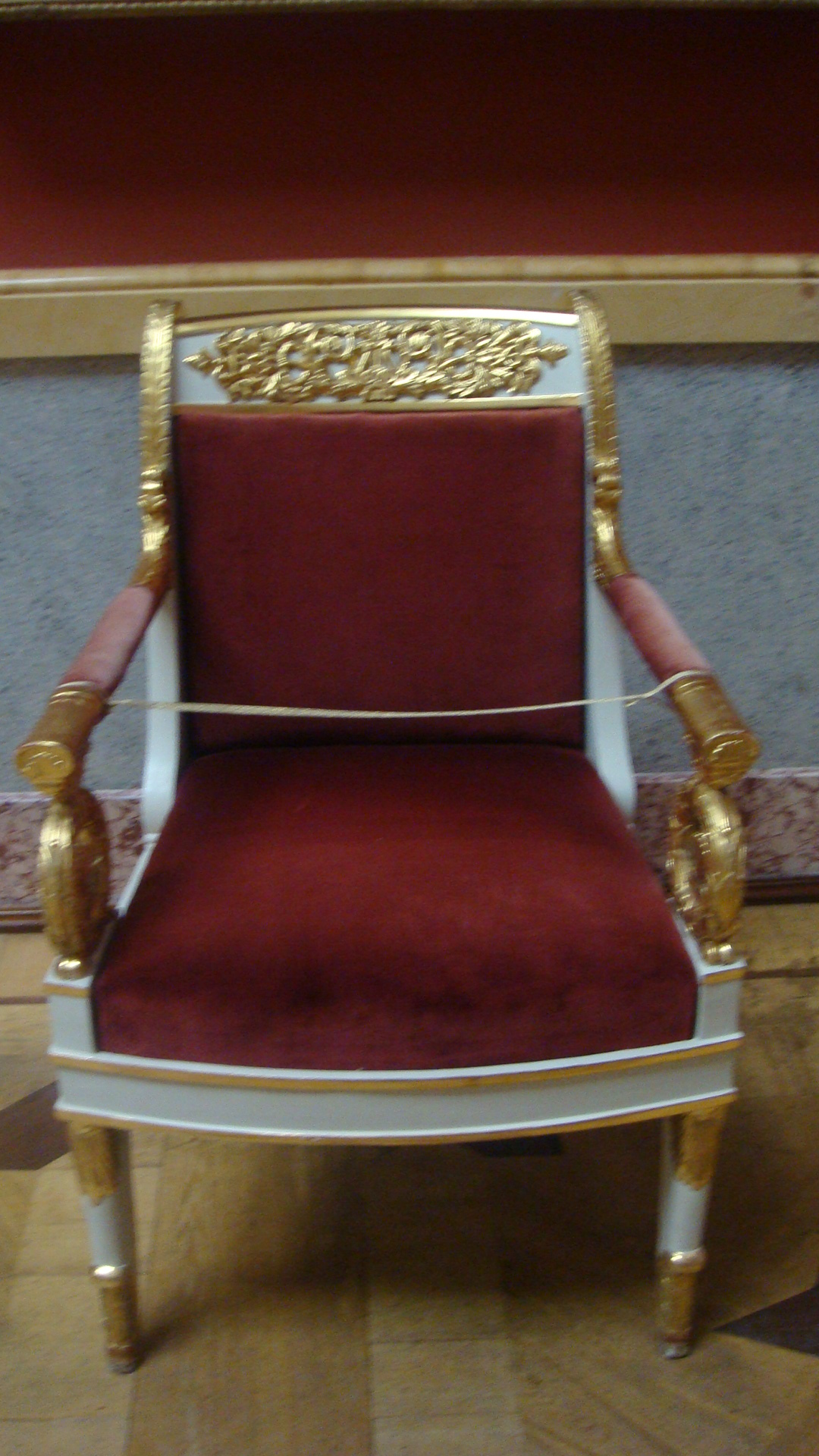 a gold and red chair with a black foot board
