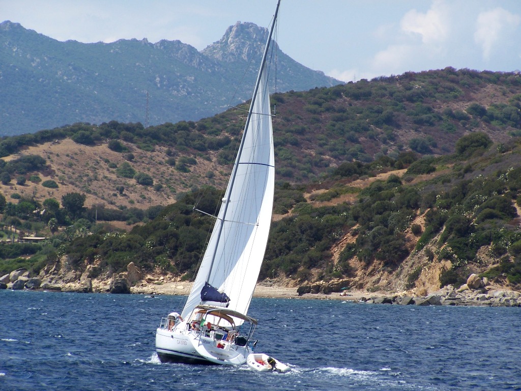 the white sailboat is sailing down the lake