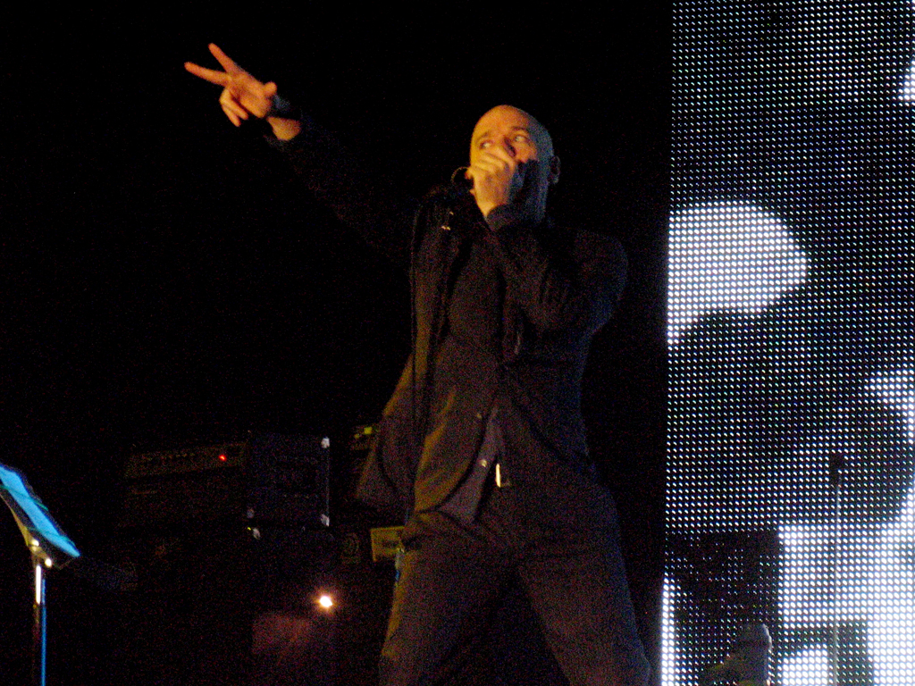 a man with his hands up standing in front of a crowd