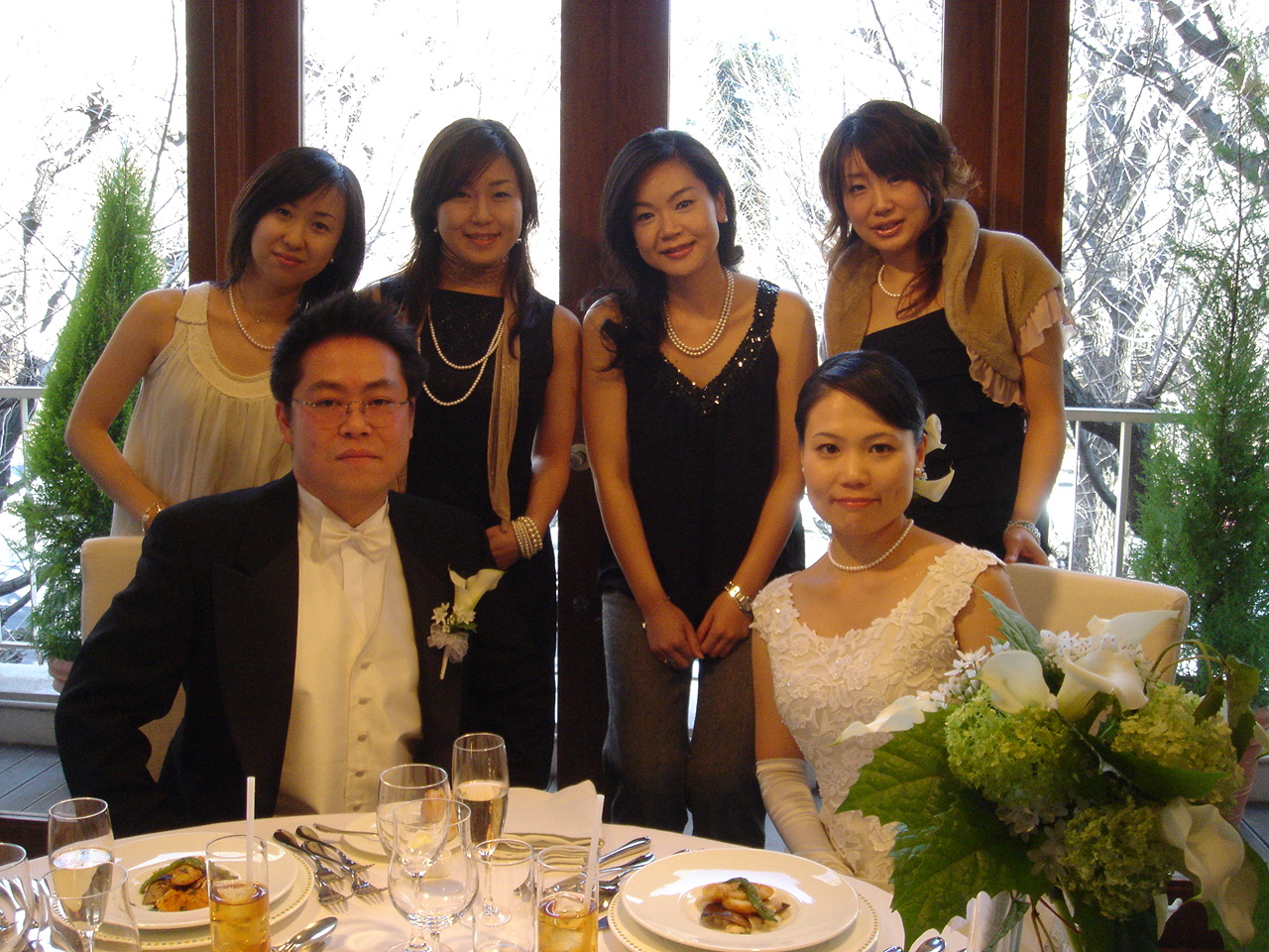 a wedding party standing in front of the dining room table