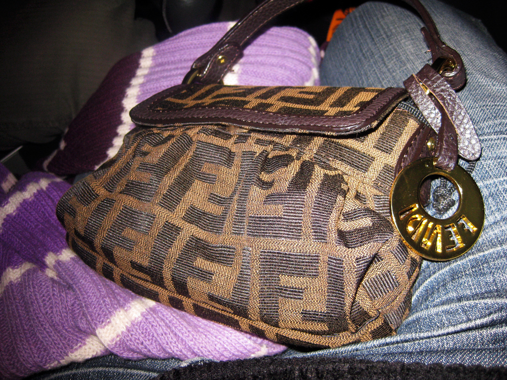 a brown purse sitting on top of a persons lap