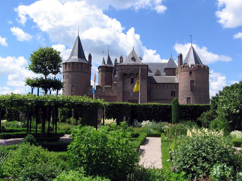 a castle is sitting among lush green shrubs