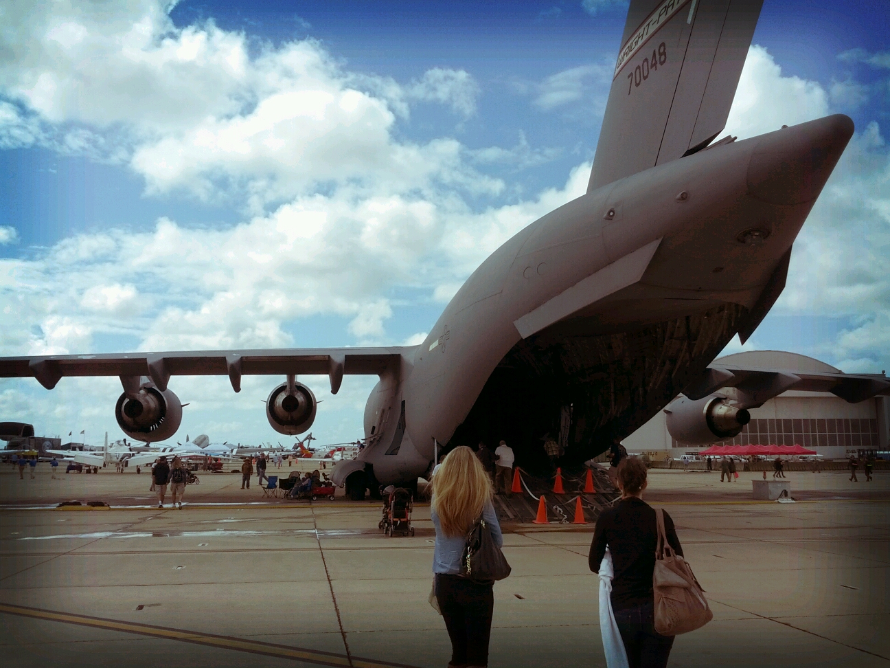 two people are walking towards an airplane on the tarmac