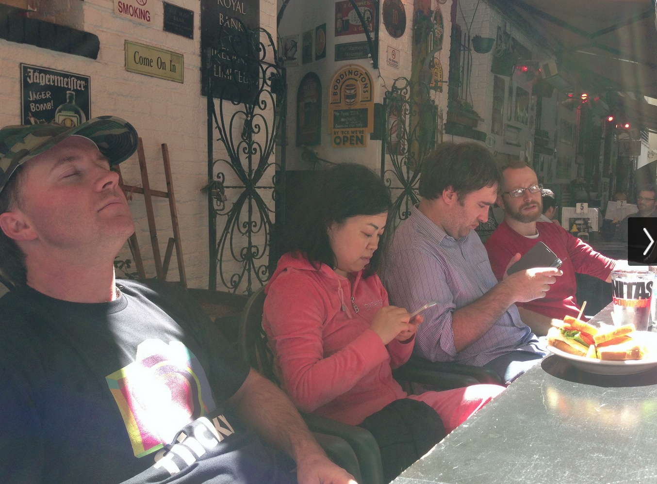 several people sitting in front of a table eating food