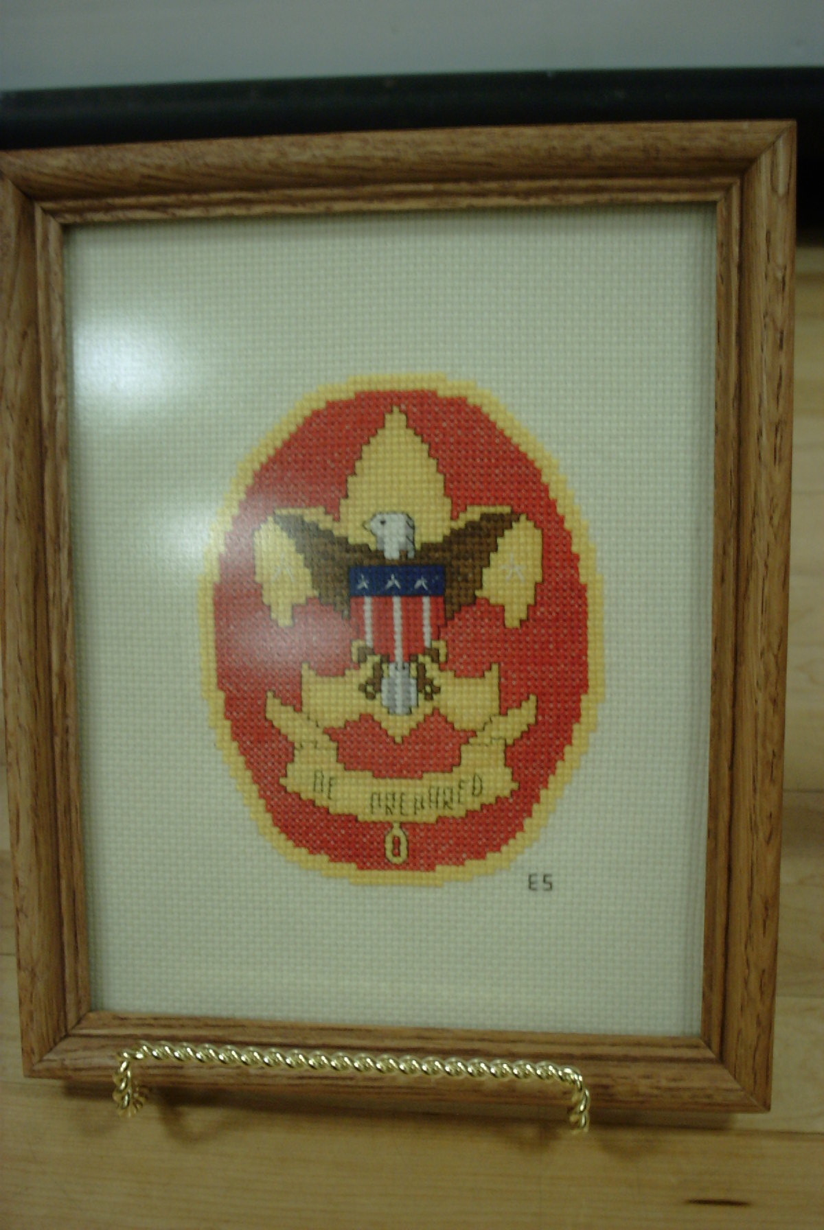 a cross stitch picture is attached to a wooden frame