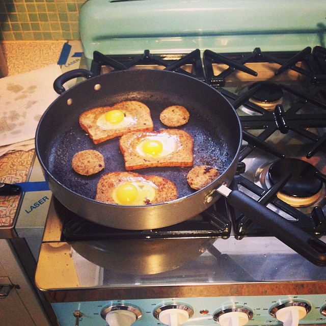 eggs and toast are being fried in a pan on top of the stove