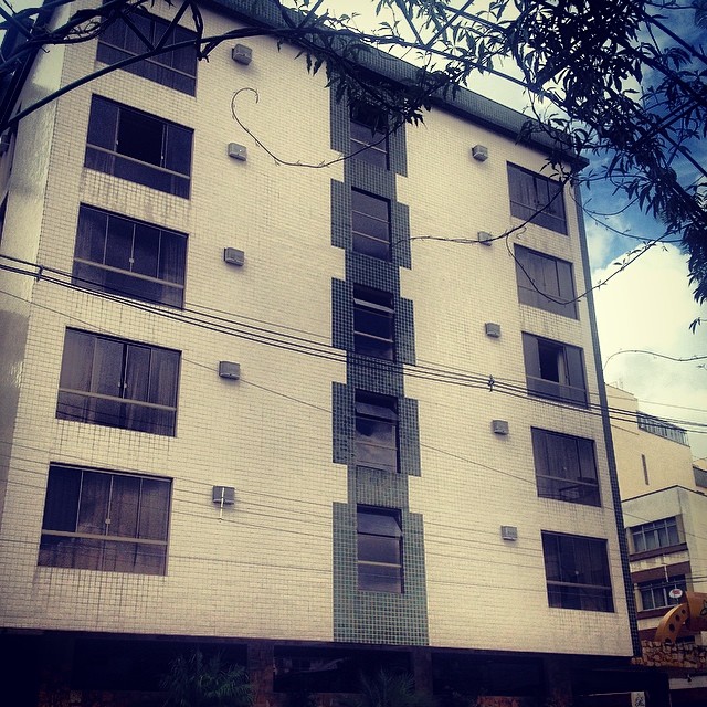 a brick apartment building with several stories that are white