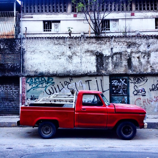 a red truck is parked in front of an old building