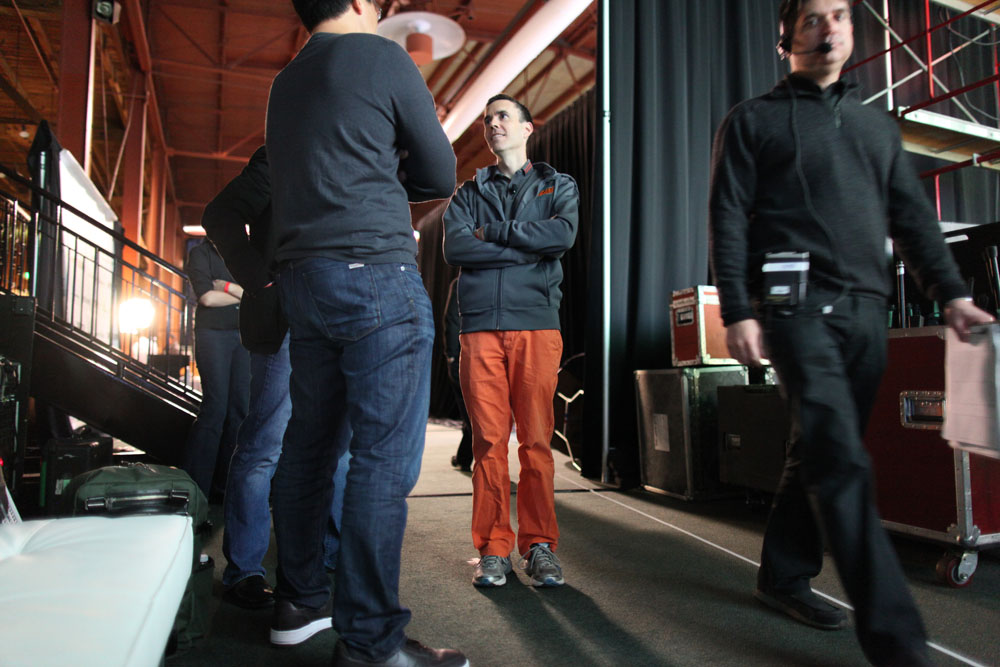 four men wearing orange pants and jackets talking to each other