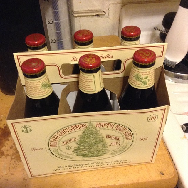 six beer bottles in a cardboard box with lids