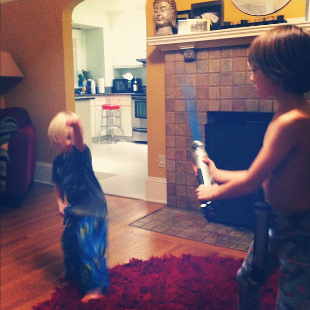 two small boys standing in front of the fireplace playing