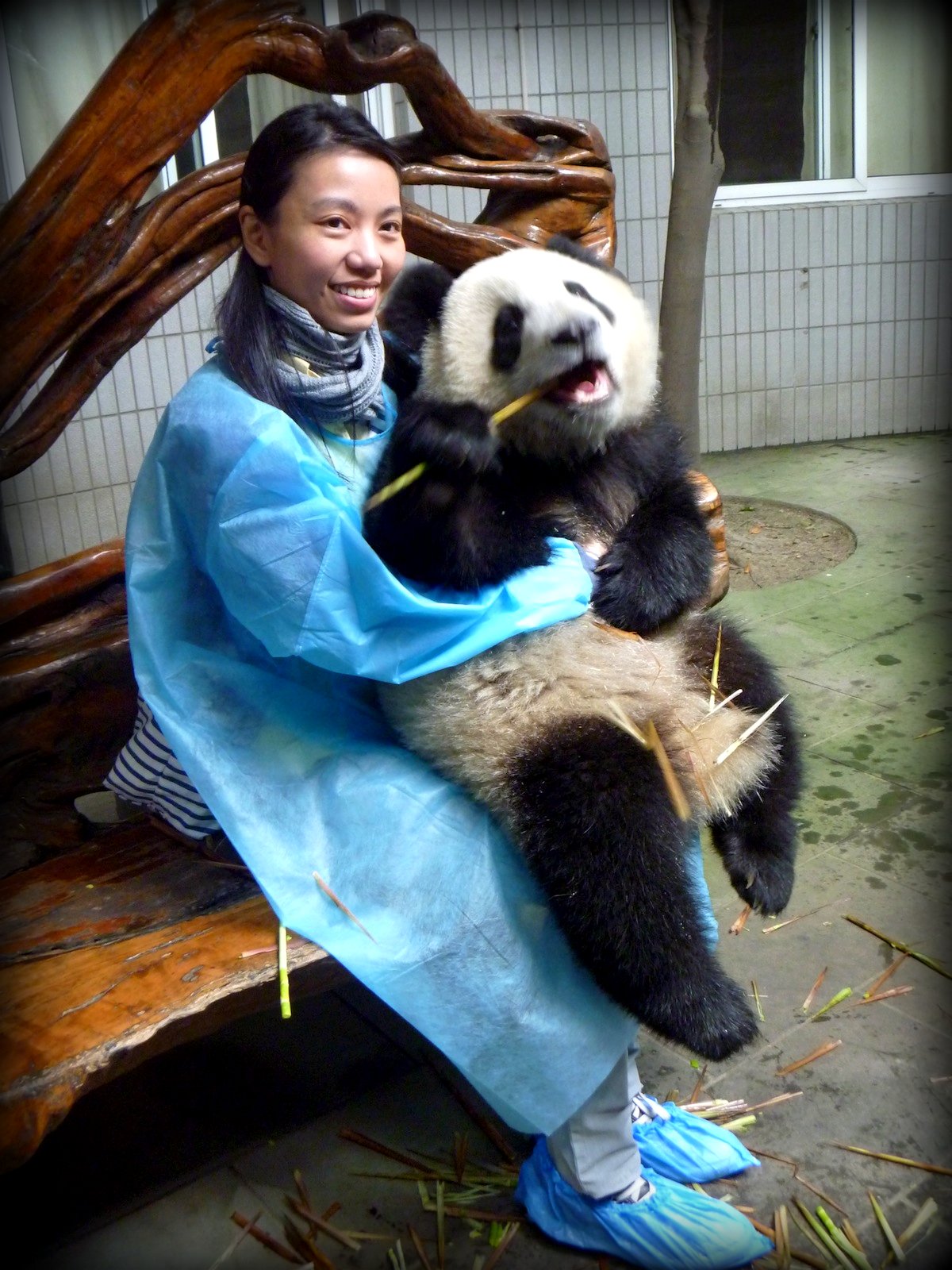 a woman sitting on a bench holding a panda bear