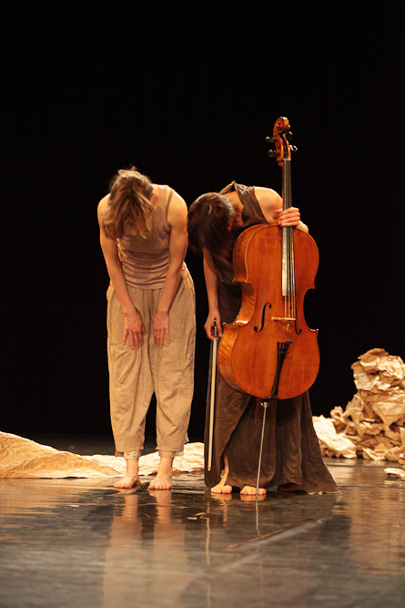 two female violinistes are performing on a stage