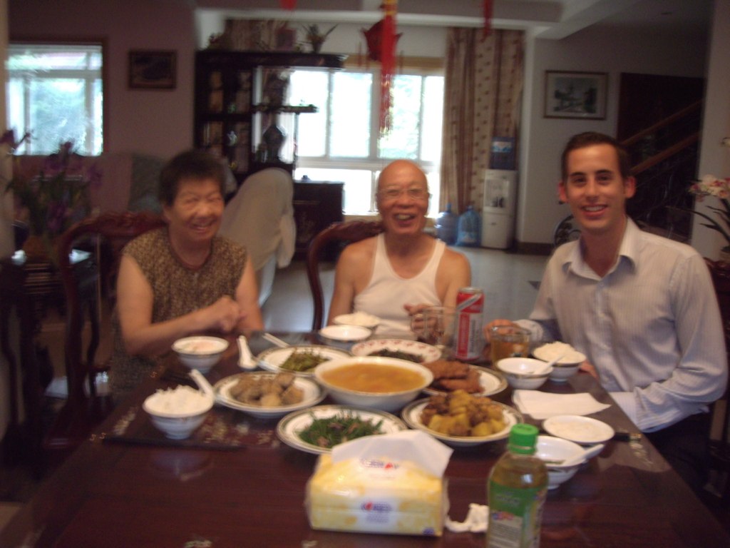 two men and a woman eating at a dining table