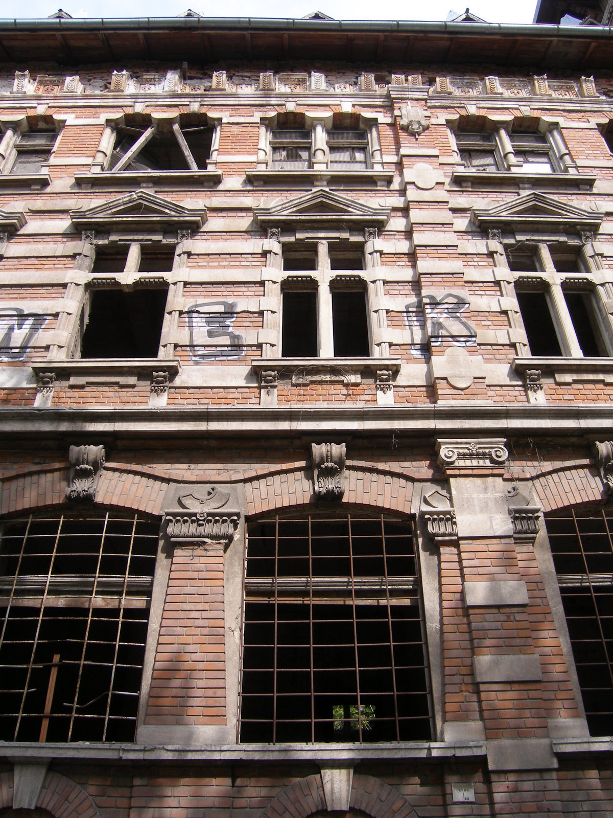 a tall building with lots of windows and broken shutters