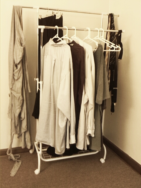 white clothes and shirts are on display in an otherwise empty room