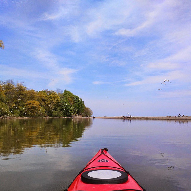 red kayak in front of beautiful lake and green trees