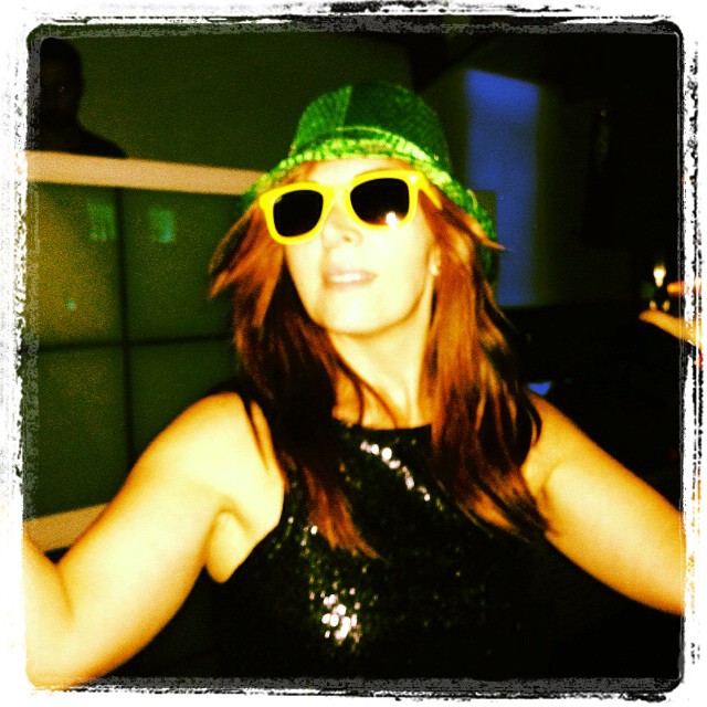 woman wearing bright green shades and a bright hat