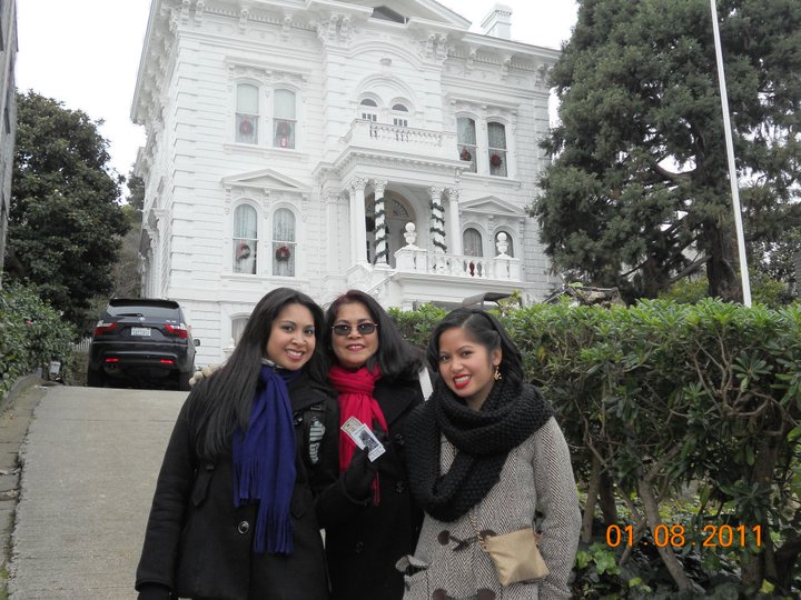 three ladies outside of a white house posing for a po