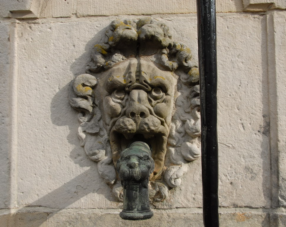 a stone head mounted on the side of a building
