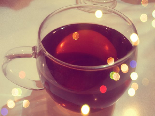 a glass mug with some tea inside of it