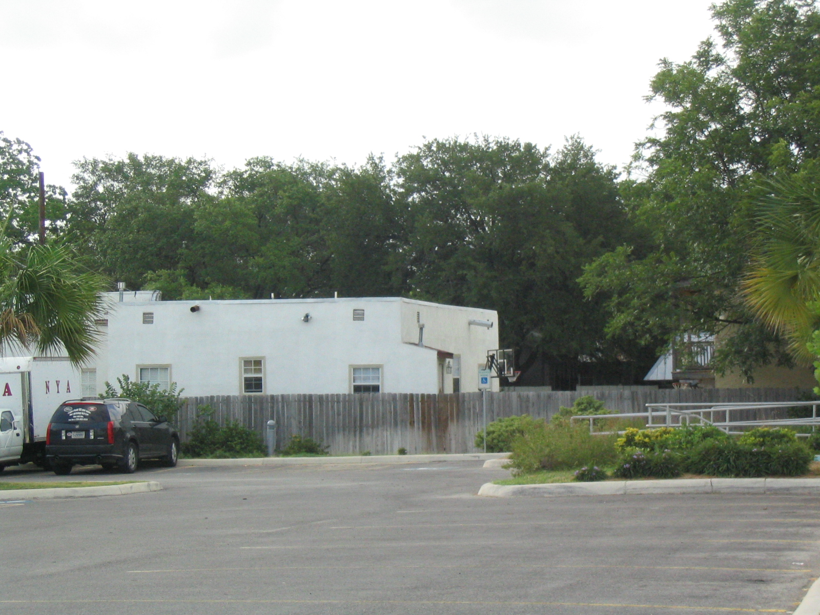 a couple of cars are parked at the curb in front of a building