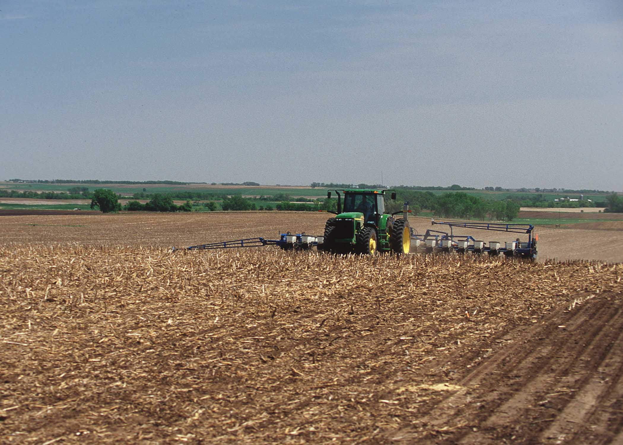 a tractor driving through a dry, plowed field