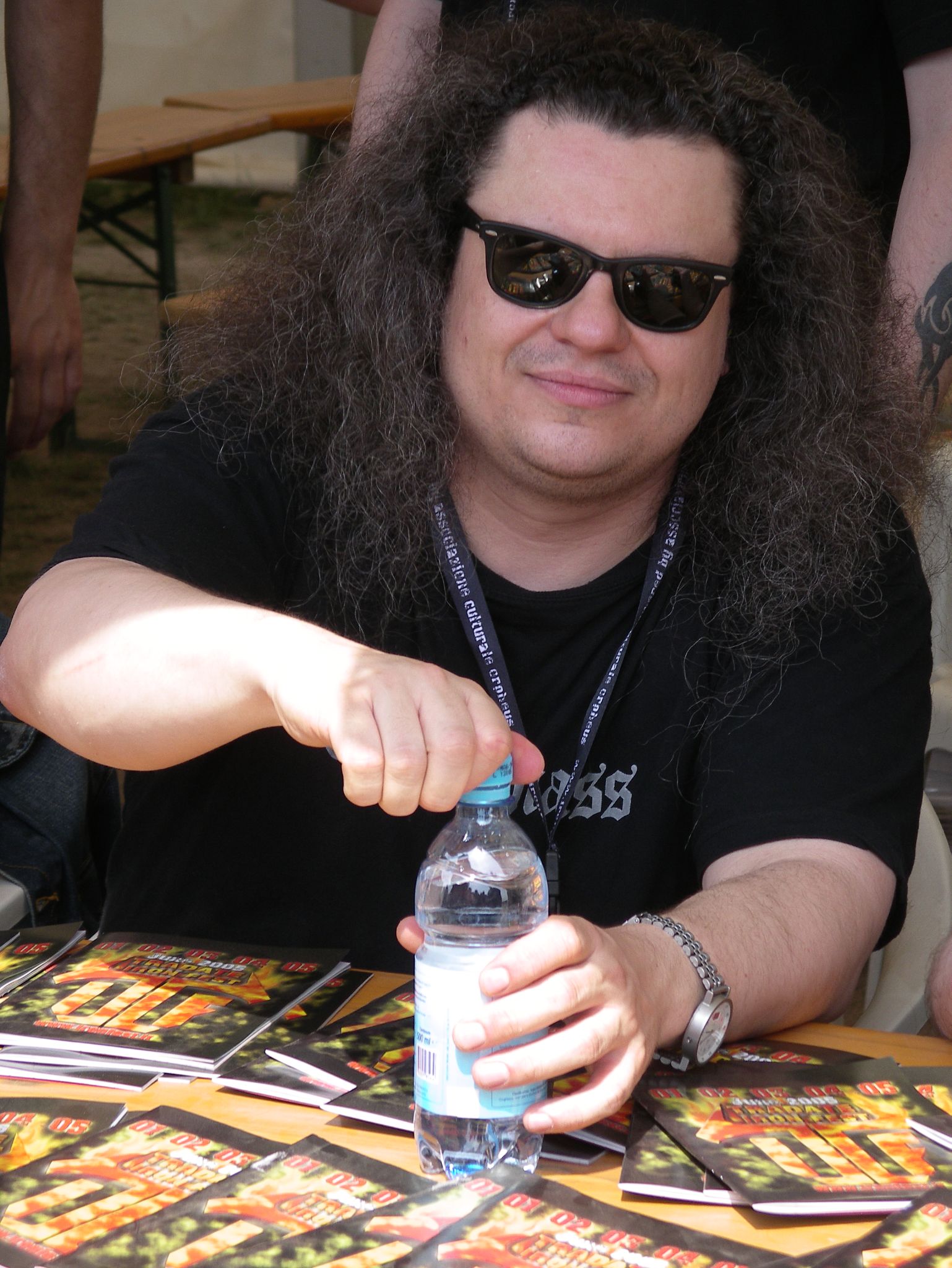 a man sitting at a table with a bottle of water in his hand