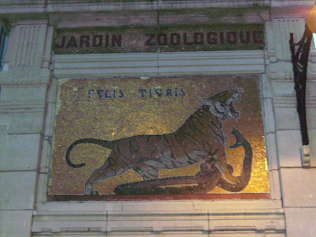 a tiled wall with a large tiger and some words