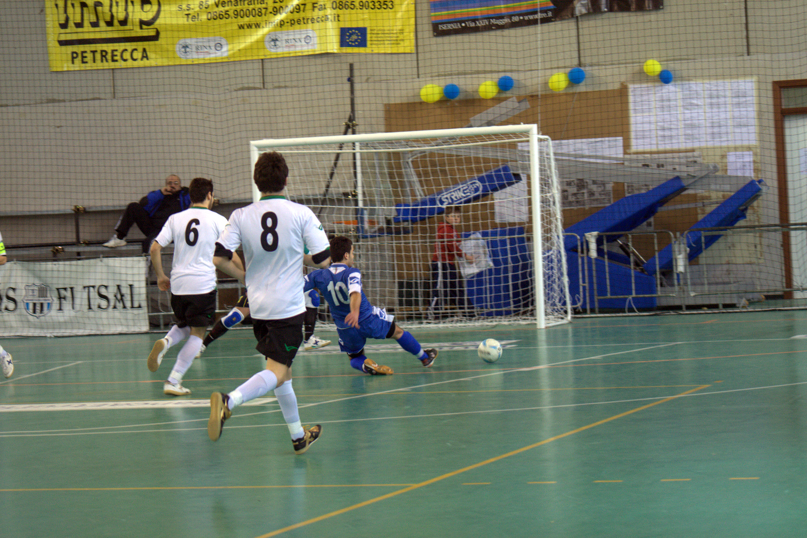 two teams of soccer players on opposing teams kicking a ball around the net