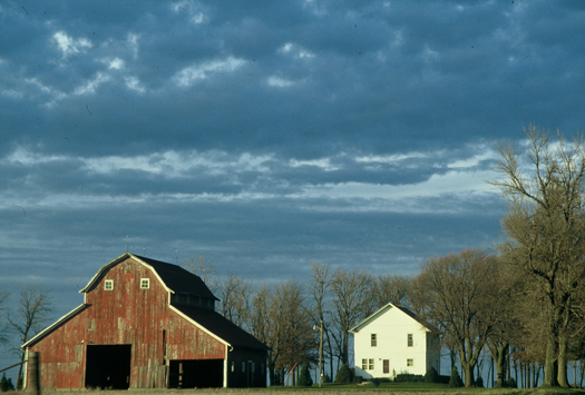 two barns sit next to each other in the field