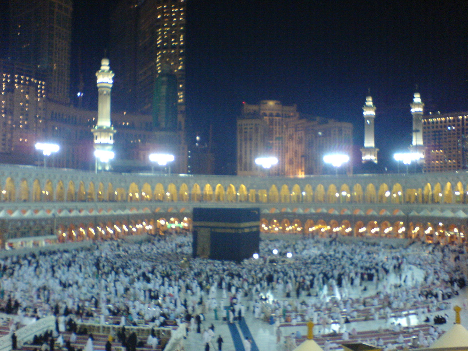 people pray in a large mosque at night