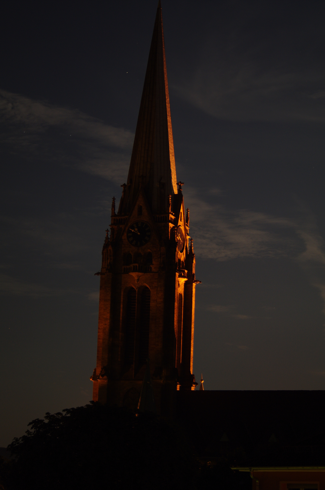 there is a church steeple with the moon above it