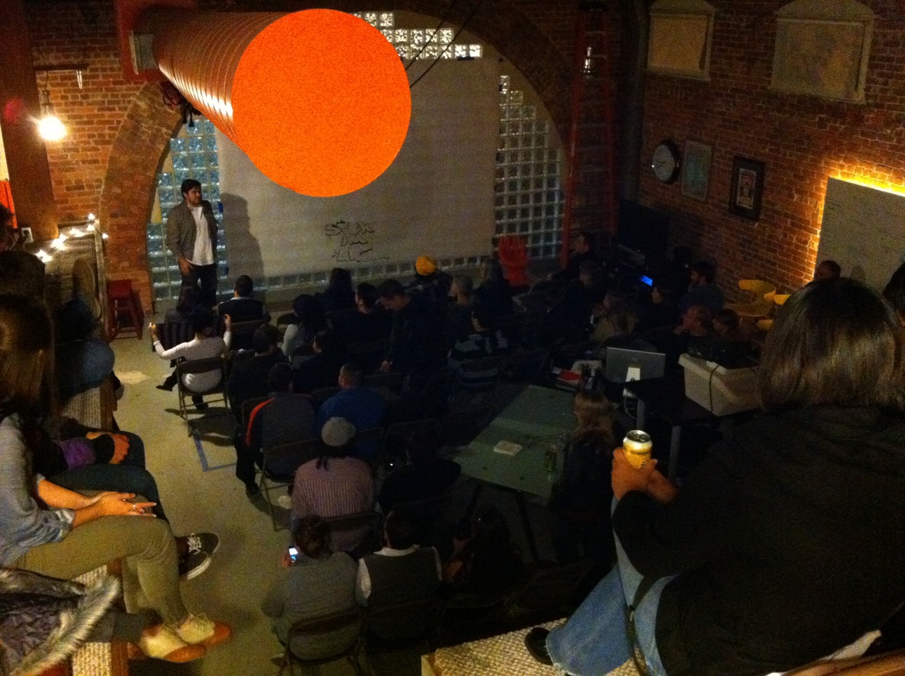 a group of people sitting down in a bricked room
