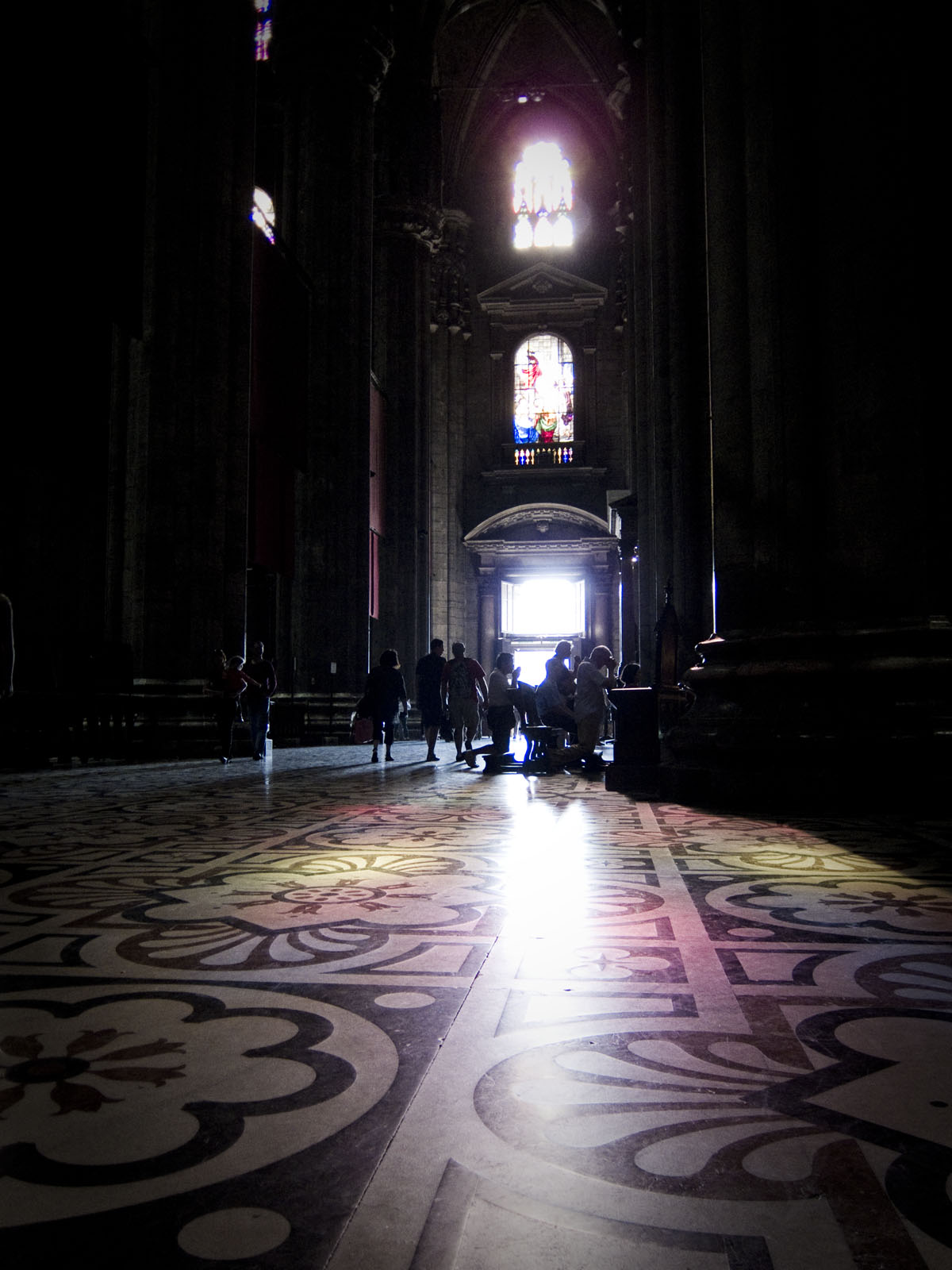 people sit on the floor inside a large building