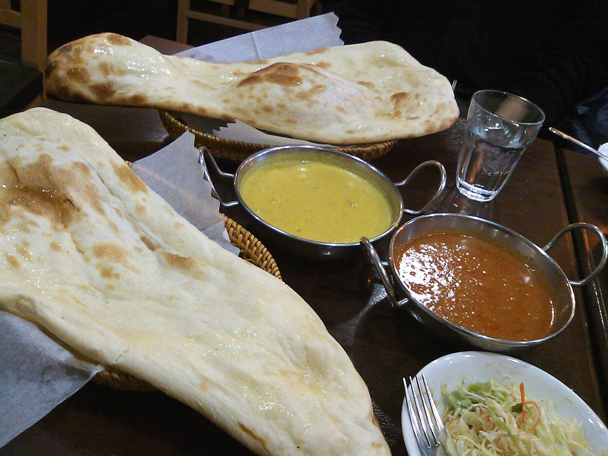 indian food including naan, curry and a side of other foods on a table