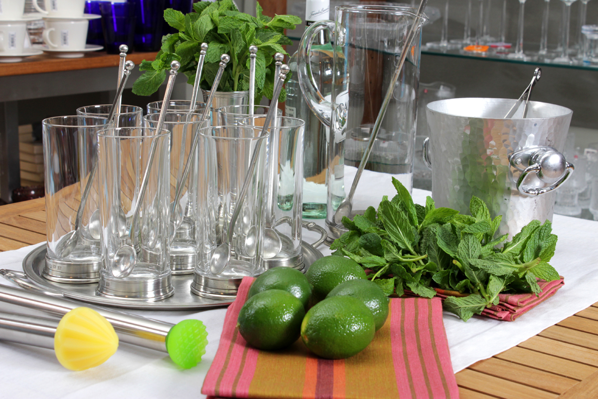 some glasses are on a table with green vegetables