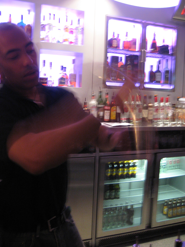 a man preparing drinks for a group at the bar