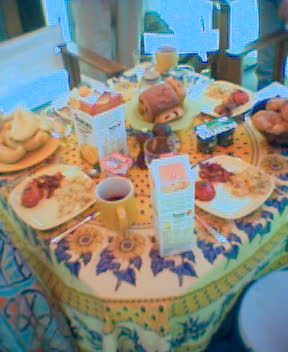 a table topped with breakfast foods and cup of coffee